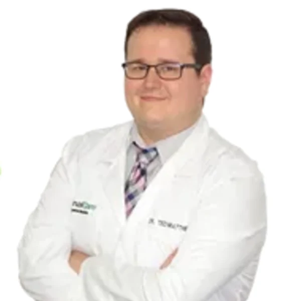 Dr. Ted Matthews, D.C., in a white coat with arms crossed