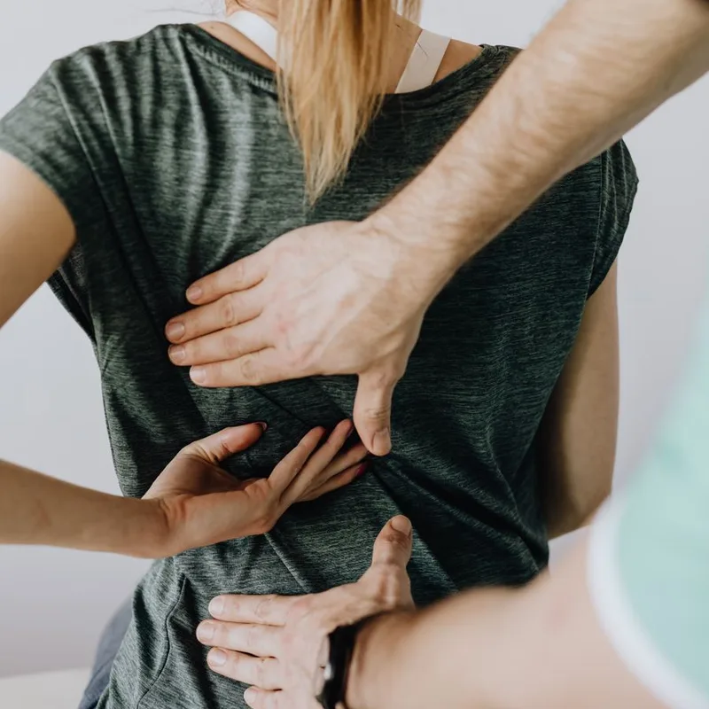 A practitioner works on a patient's lower spine