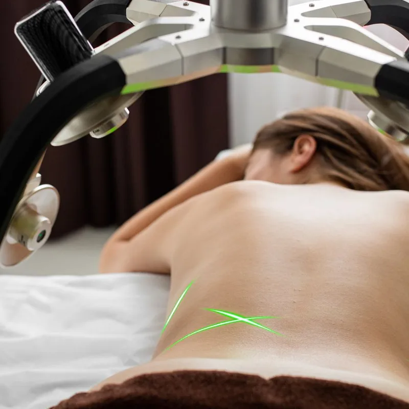 A therapeutic laser treats a patient's back